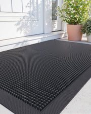 DEXI front view of 24x36 black rubber door mat showing full shape and curb appeal
