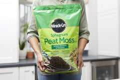 Miracle-Gro bag being mixed into garden soil to improve drainage and aeration