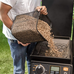 Oklahoma Joe's heavy-duty scoop transferring pellets into a grill hopper for fast loading