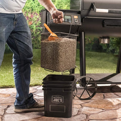 Oklahoma Joe's pellet bucket beside a 20 lb bag showing compact scale and convenience