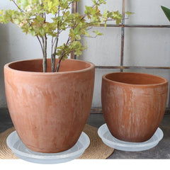 OVZILKI saucer in use under a large pot protecting indoor floor