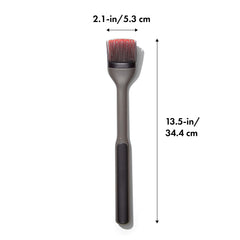 OXO brush basting ribs on grill with long handle keeping hands safely away from heat