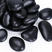 Pulovin front bag with spilled black river rocks showing quantity and benefit