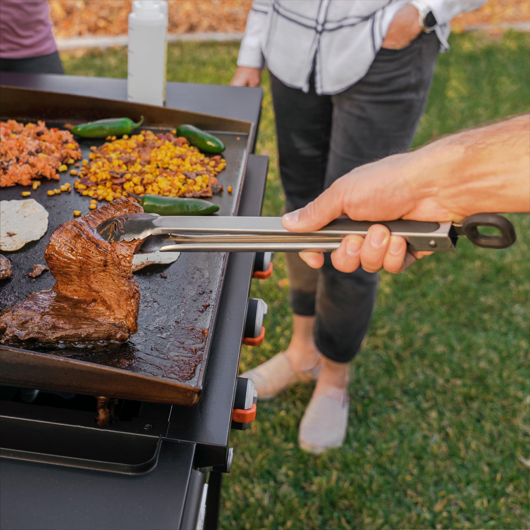 Blackstone lifestyle backyard cookout with kit helping serve a large group