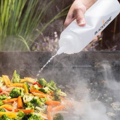 Blackstone tools in use on griddle flipping burgers and eggs for faster cooking
