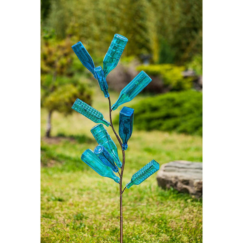 Evergreen Family Products staked bottle tree in garden showing easy installation and stability