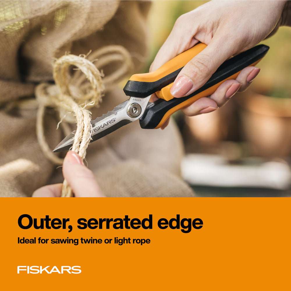 Fiskars shears cutting rope in garden, reliable multipurpose performance