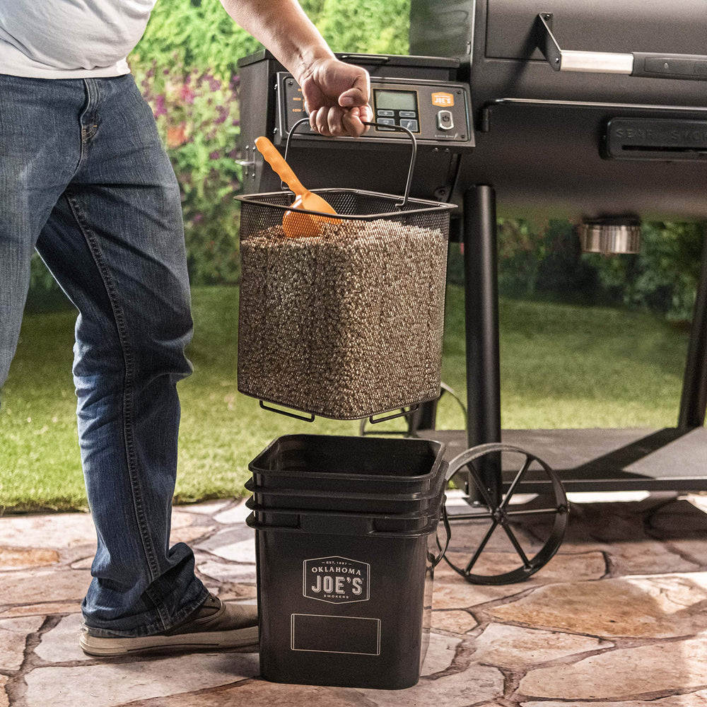 Oklahoma Joe's pellet bucket beside a 20 lb bag showing compact scale and convenience