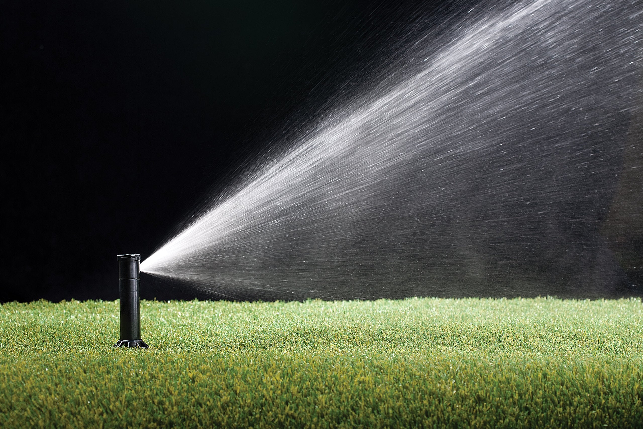 Rain Bird CP3504PC popped up in tall grass showing 4 inch height keeps spray above turf