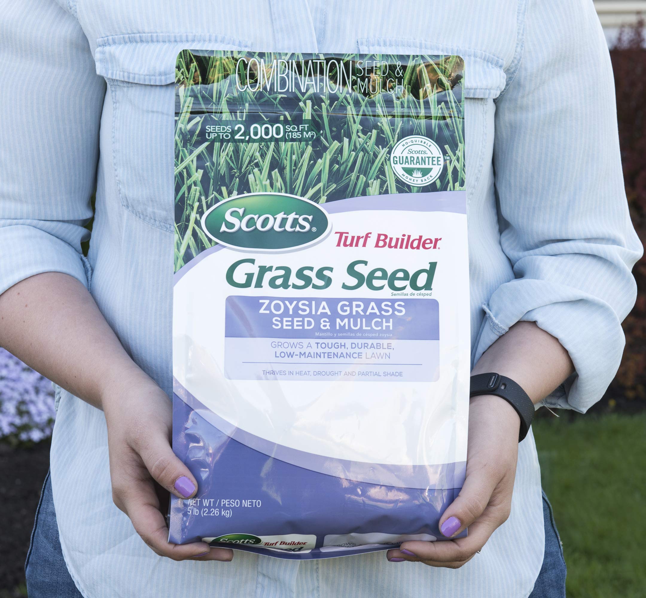 Scotts seeds being spread on prepared soil for even germination