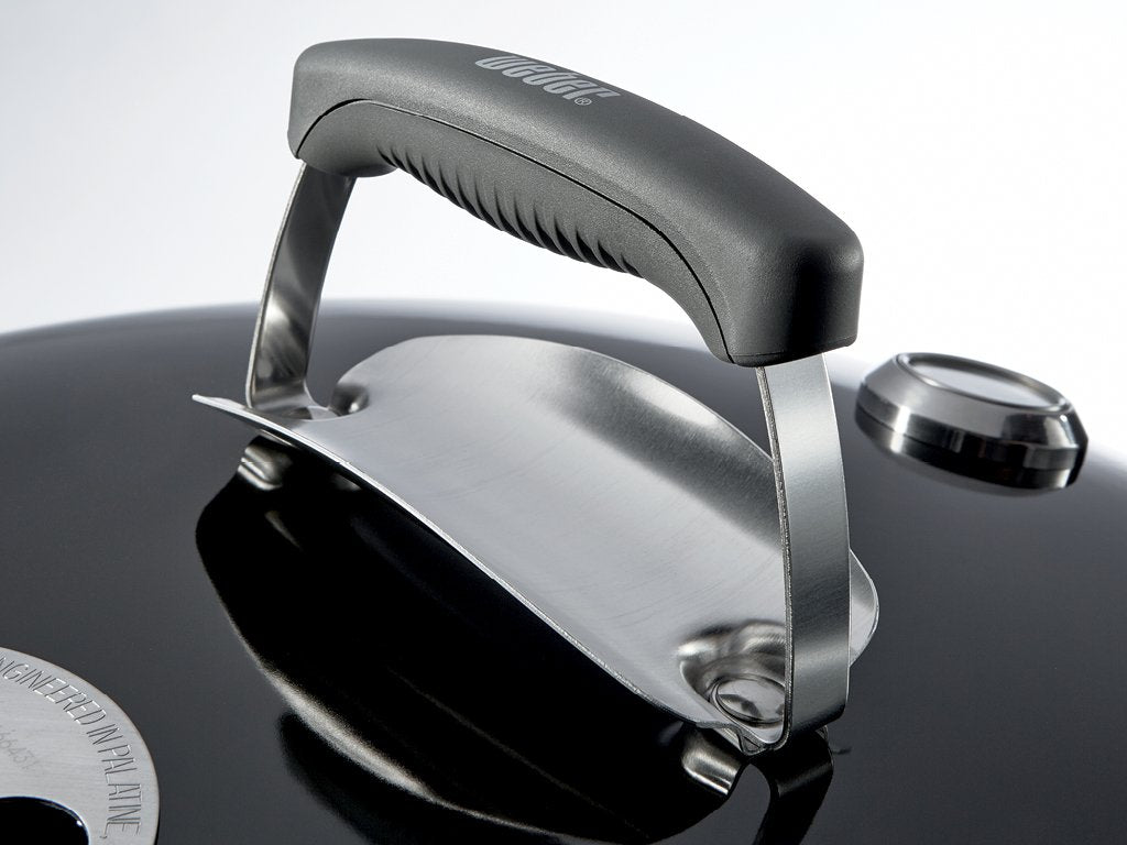 Weber grill in backyard lifestyle scene illustrating social cooking and compact footprint