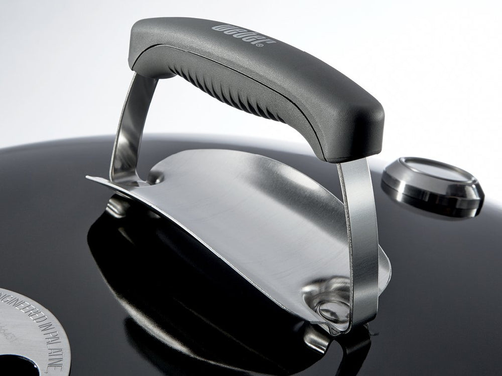 Weber grill in backyard lifestyle scene illustrating social cooking and compact footprint