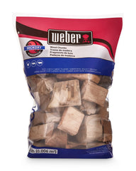Weber hickory chunks on hot coals inside grill producing steady smoke for flavor