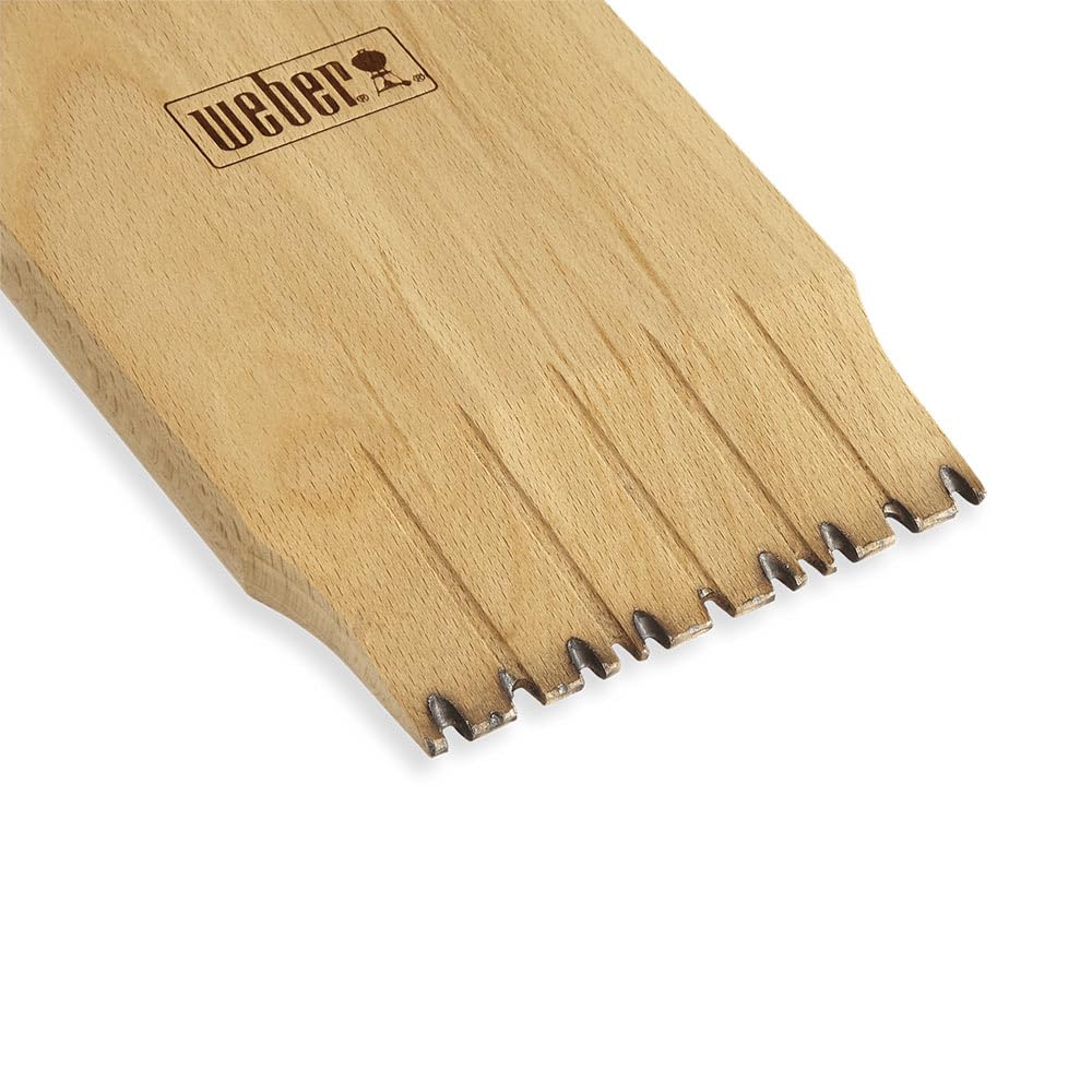 Weber wood scraper in use scraping grill grates to remove residue